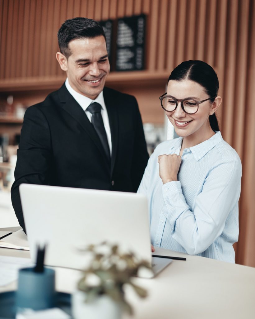 two-smiling-businesspeople-using-a-laptop-together-in-an-office-pjf2614ivd8uvujcszjxmyn3mfdemrqd8up1cl78qo